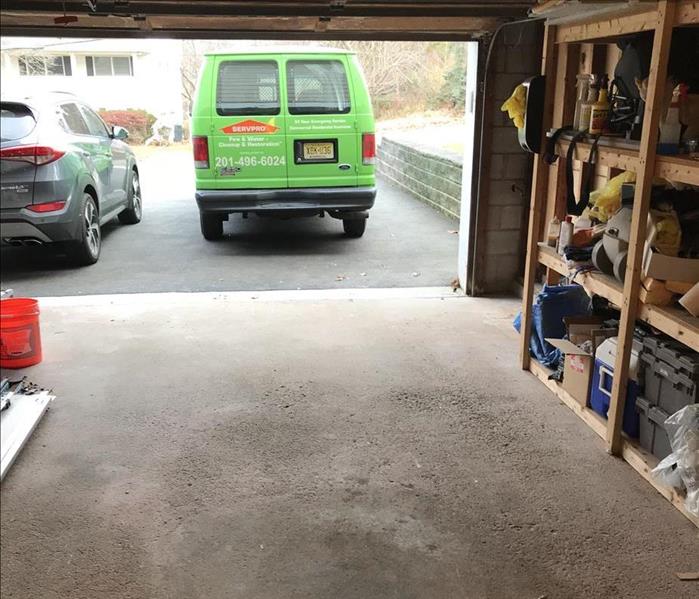 Same view, no garage door with a SERVPRO van in the driveway, neat and clean, with exposed building elements