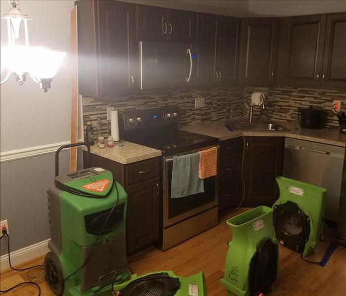Three SERVPRO air movers and one dehumidifier are drying an open kitchen ceiling cavity